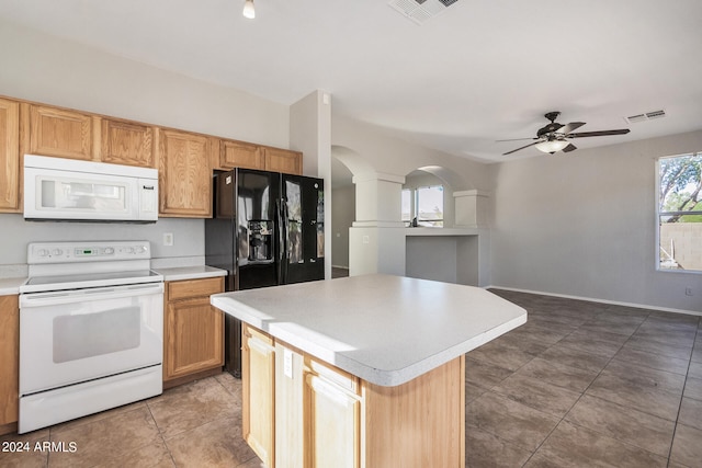 kitchen with tile patterned flooring, white appliances, a center island, and ceiling fan