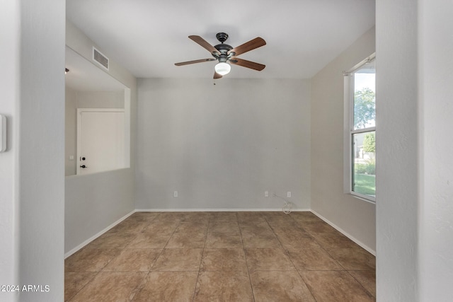 tiled empty room featuring ceiling fan