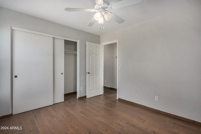 unfurnished bedroom with ceiling fan, a closet, and dark hardwood / wood-style flooring