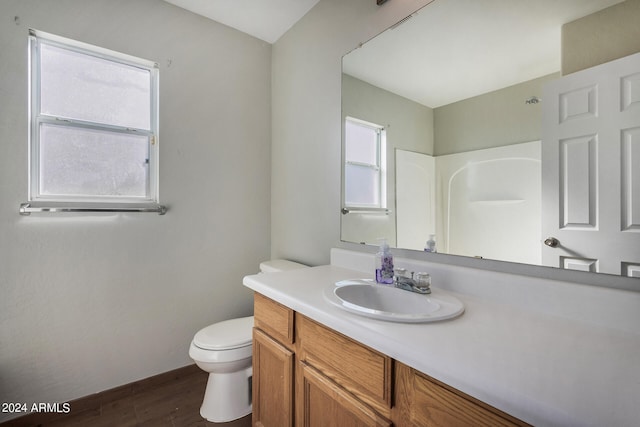 bathroom featuring vanity, toilet, and hardwood / wood-style floors