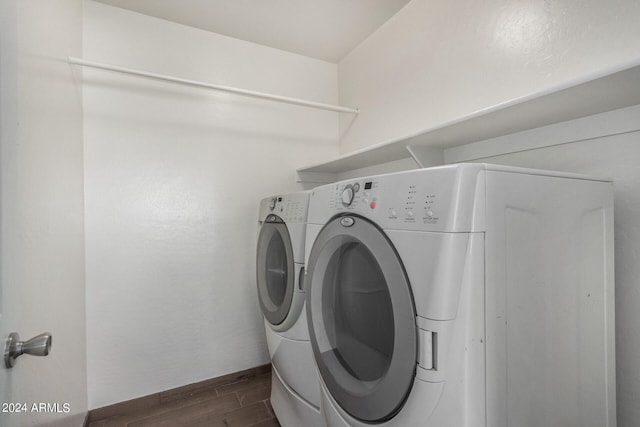 clothes washing area featuring dark hardwood / wood-style flooring and washing machine and dryer