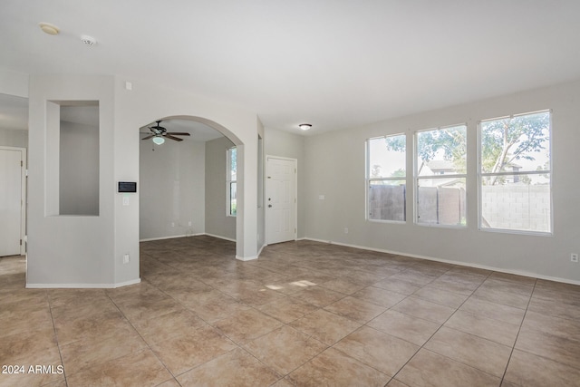 tiled spare room with ceiling fan