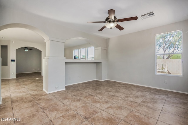 tiled spare room featuring plenty of natural light and ceiling fan