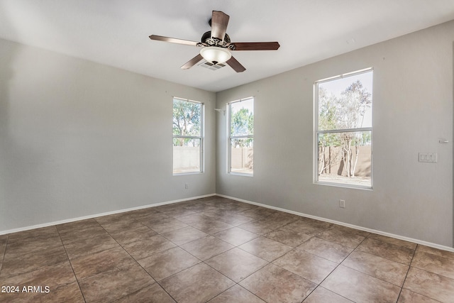 tiled spare room featuring ceiling fan