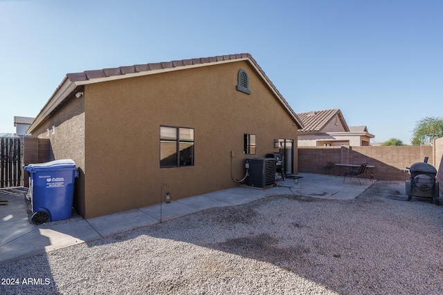 back of property featuring central air condition unit and a patio