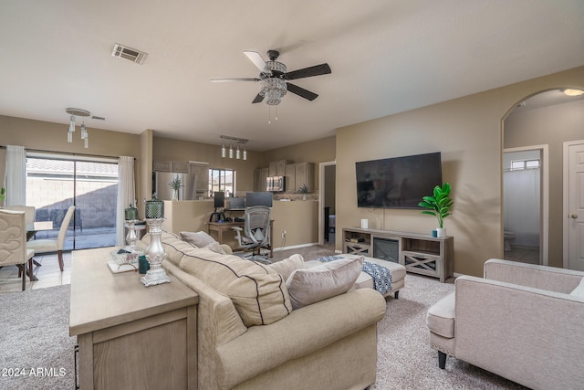 living room with ceiling fan and light colored carpet