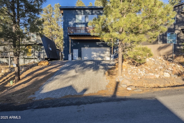 view of front of home with a garage and a balcony