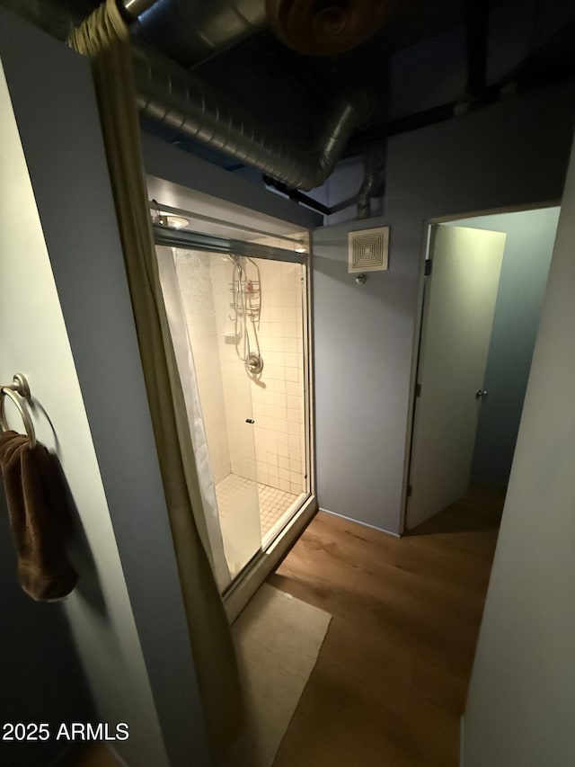 bathroom featuring a shower stall and wood finished floors