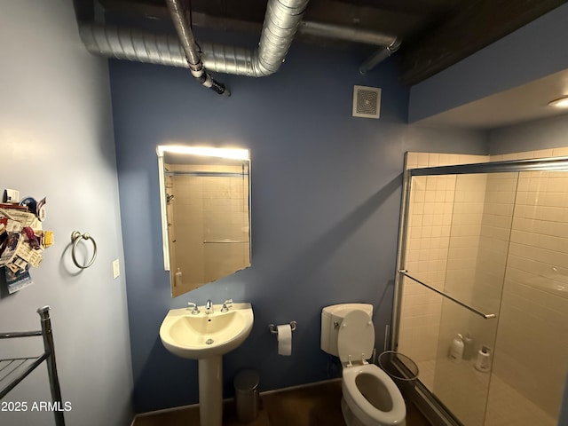 full bathroom with toilet, a stall shower, and visible vents