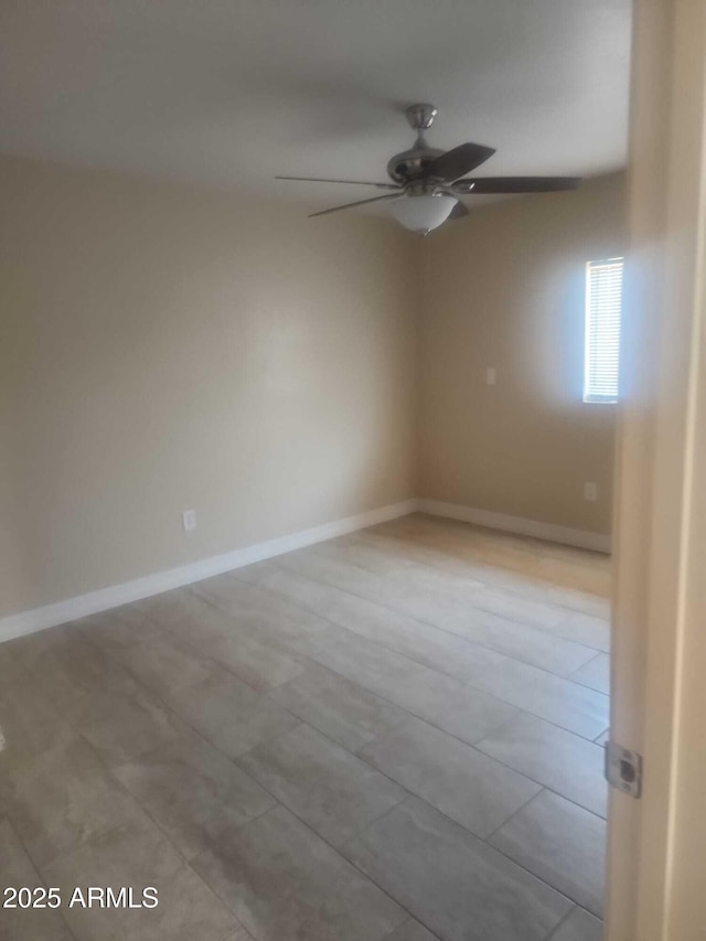 unfurnished room with baseboards and a ceiling fan