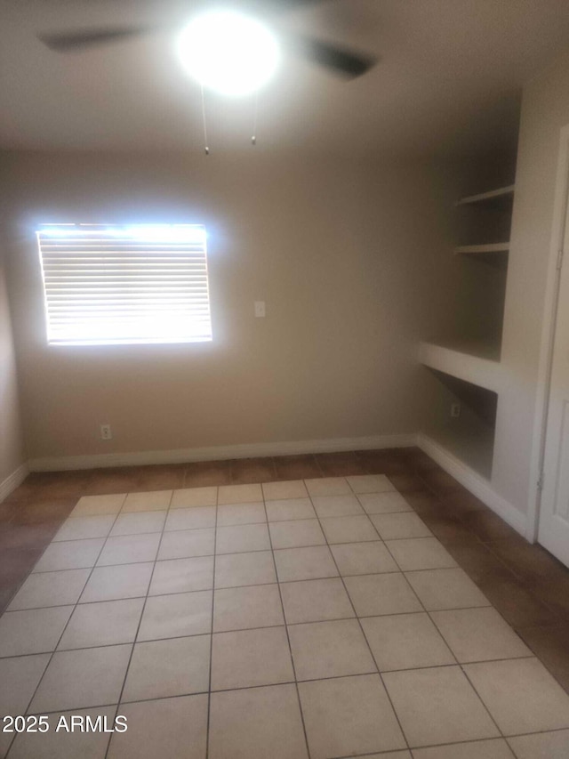 spare room featuring light tile patterned floors and baseboards