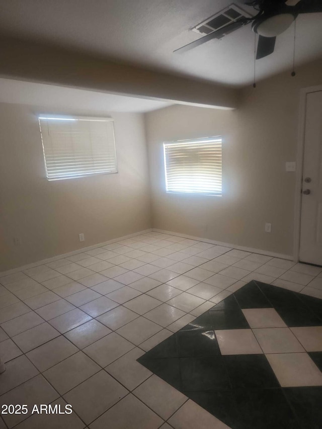 spare room featuring ceiling fan and light tile patterned floors