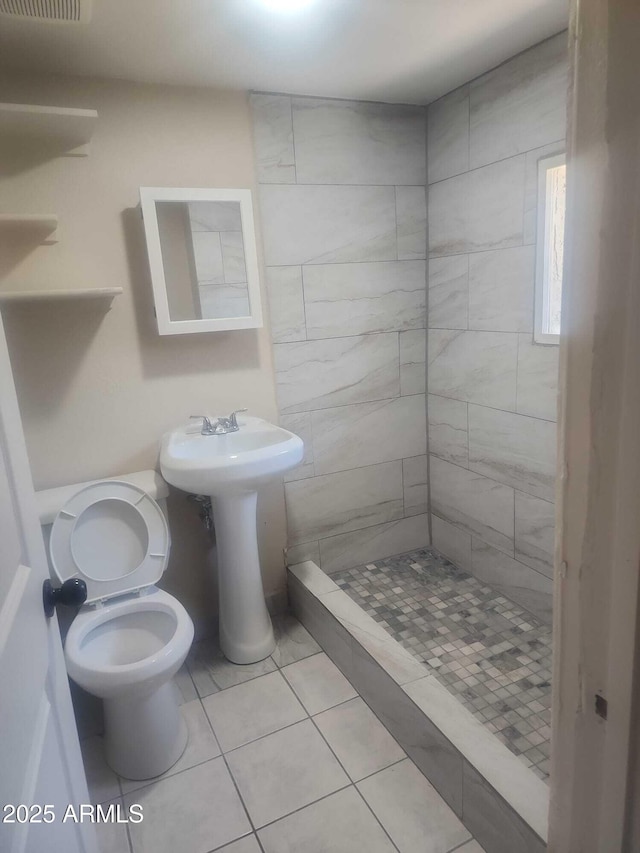 bathroom with a shower stall, tile patterned flooring, and toilet