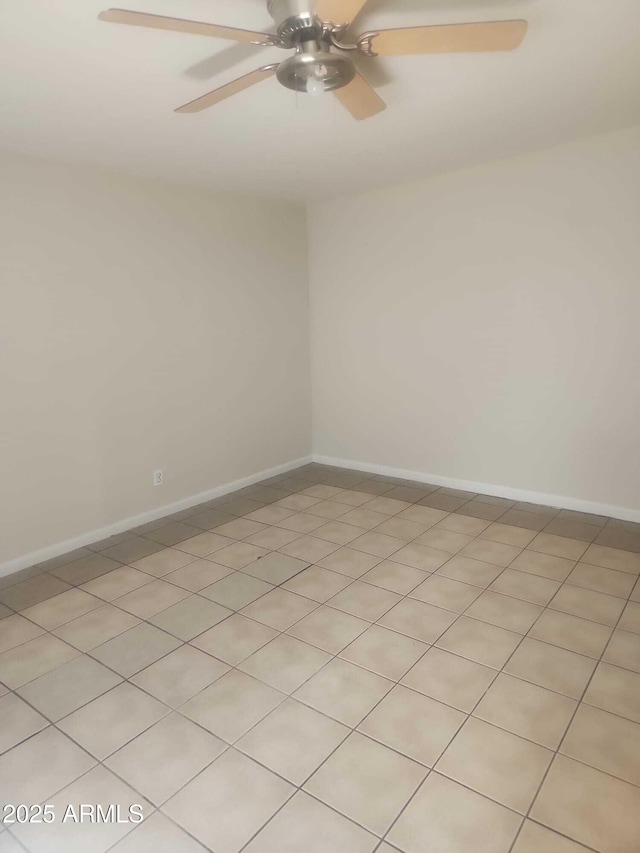 spare room featuring a ceiling fan and baseboards