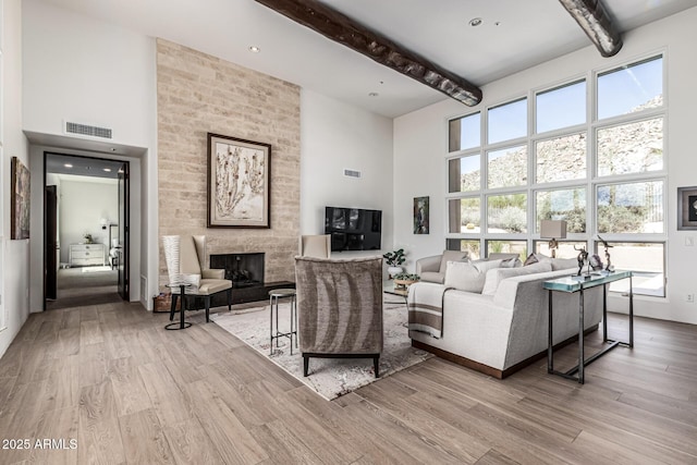 25825 N 106th Way, Scottsdale, AZ 85255 - living room featuring a towering ceiling, beam ceiling, wood finished floors, and a large fireplace