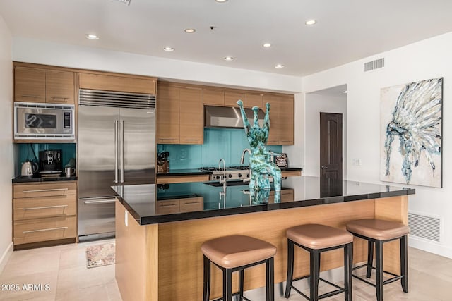 25825 N 106th Way, Scottsdale, AZ 85255 - kitchen featuring built in appliances, a kitchen breakfast bar, dark countertops, and recessed lighting