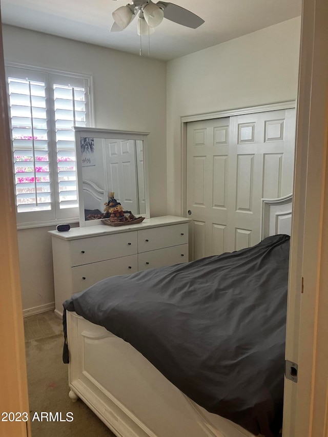 carpeted bedroom with ceiling fan and a closet