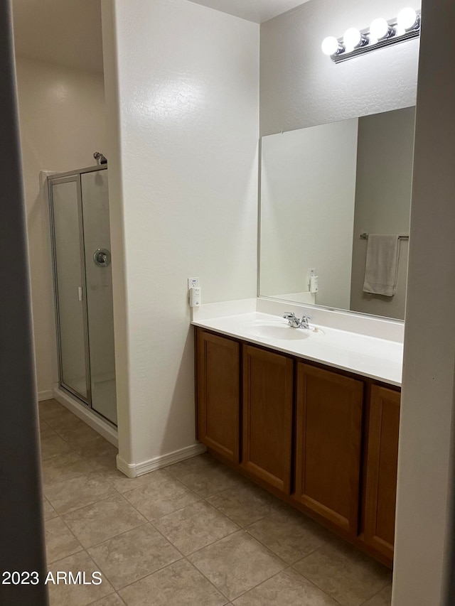 bathroom with tile floors, vanity, and a shower with shower door