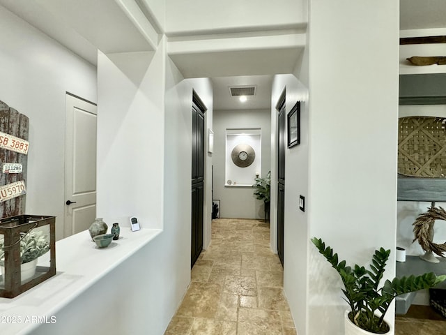 corridor with stone tile flooring and visible vents