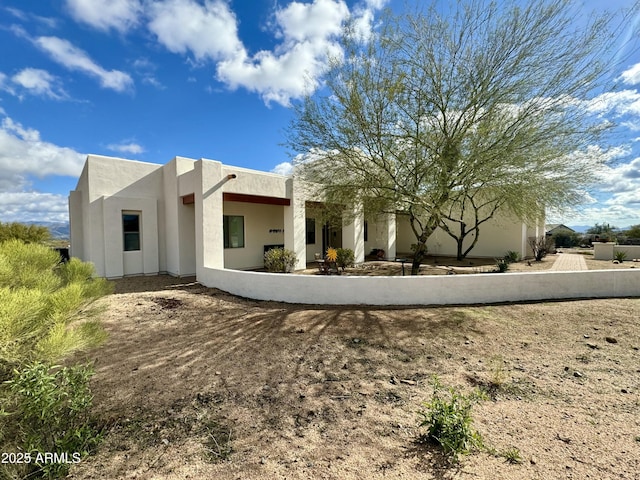 rear view of house featuring stucco siding