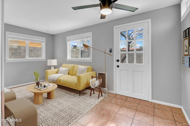 interior space featuring baseboards, a ceiling fan, and light tile patterned flooring