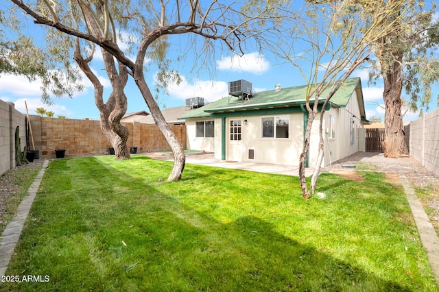 back of property featuring stucco siding, a lawn, central AC unit, a patio area, and a fenced backyard