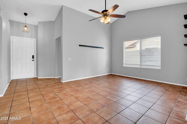 interior space featuring ceiling fan, light tile patterned floors, lofted ceiling, and baseboards