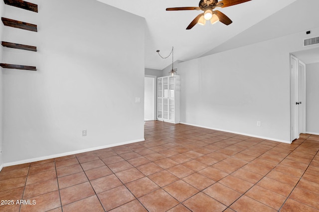 spare room with a ceiling fan, visible vents, vaulted ceiling, and baseboards