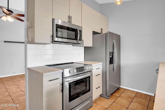 kitchen with stainless steel appliances, light countertops, decorative backsplash, and light tile patterned floors