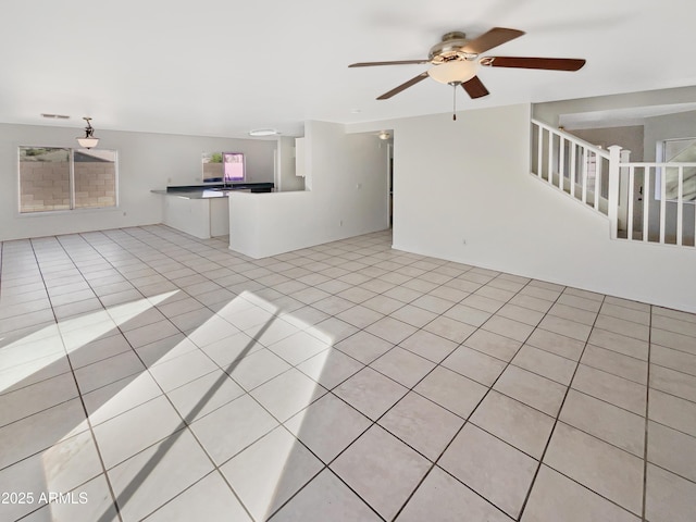 unfurnished living room with light tile patterned flooring and ceiling fan