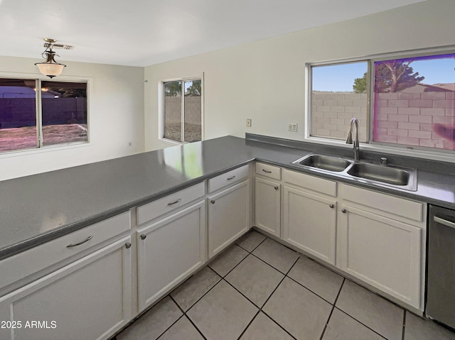 kitchen featuring white cabinetry, dishwasher, sink, and a wealth of natural light