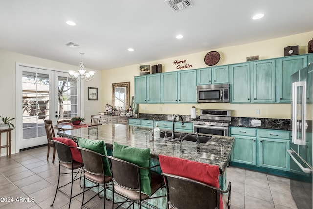 kitchen with pendant lighting, dark stone countertops, appliances with stainless steel finishes, and french doors