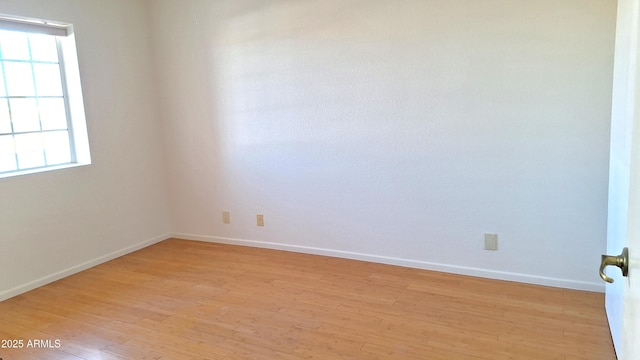 empty room with light hardwood / wood-style floors and plenty of natural light