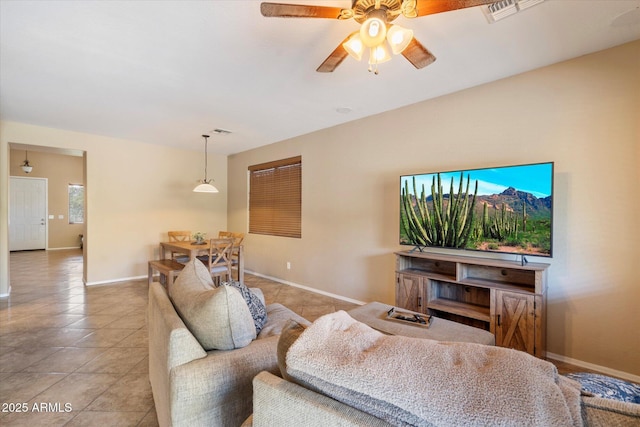 living area with light tile patterned flooring, visible vents, and baseboards