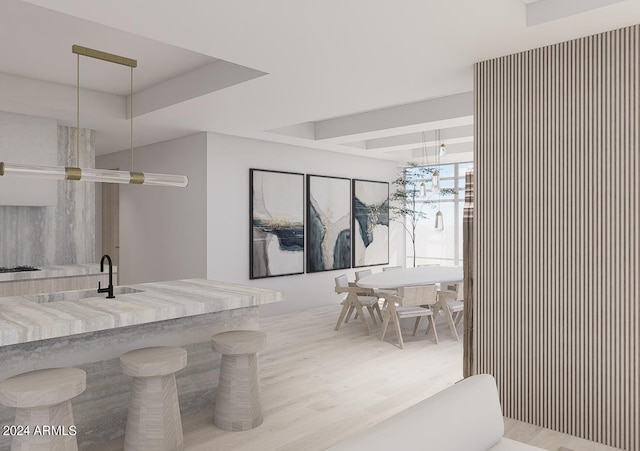 interior space featuring pendant lighting, sink, gas cooktop, and light hardwood / wood-style flooring