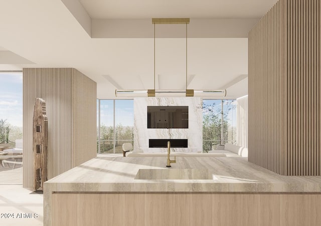 kitchen with sink, a fireplace, and light brown cabinetry