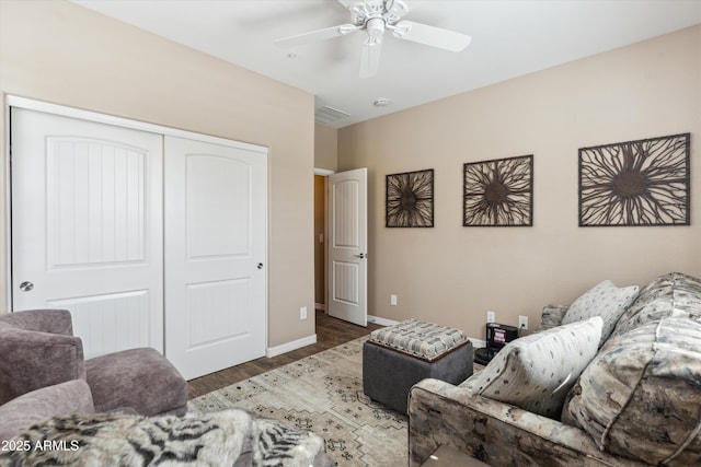 living area featuring visible vents, ceiling fan, baseboards, and wood finished floors