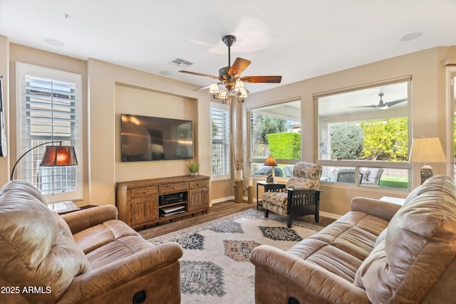 living room featuring visible vents, ceiling fan, baseboards, and wood finished floors