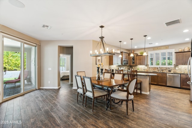 dining room featuring dark wood-style floors, a chandelier, visible vents, and baseboards