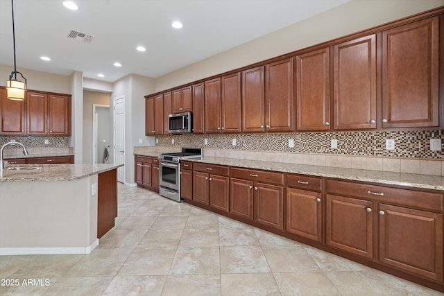 kitchen featuring tasteful backsplash, visible vents, hanging light fixtures, appliances with stainless steel finishes, and light stone countertops