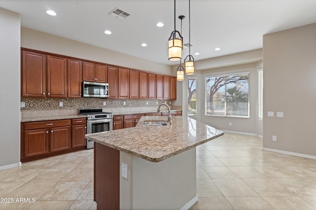 kitchen with visible vents, hanging light fixtures, backsplash, appliances with stainless steel finishes, and a sink