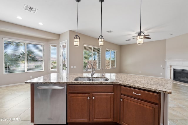 kitchen with visible vents, open floor plan, a sink, and a glass covered fireplace