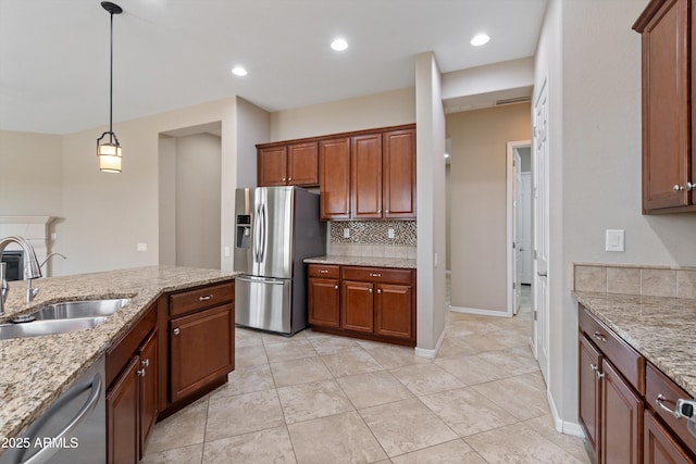 kitchen with light stone counters, stainless steel appliances, tasteful backsplash, hanging light fixtures, and a sink