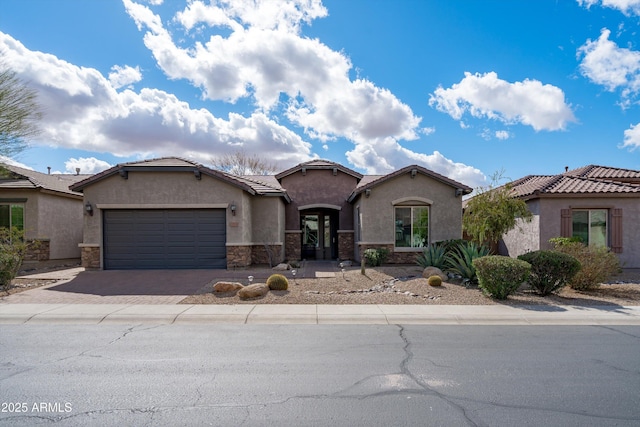 view of front facade with driveway, stone siding, a tiled roof, an attached garage, and stucco siding