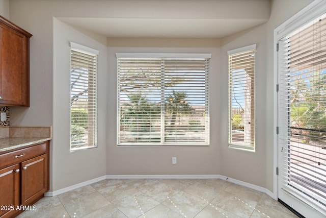 unfurnished dining area with baseboards