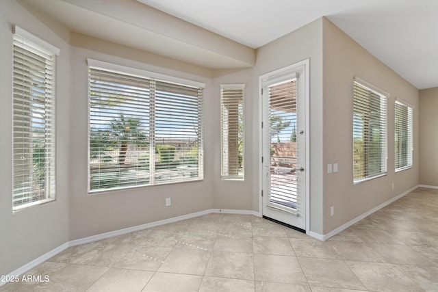 doorway to outside with light tile patterned floors and baseboards