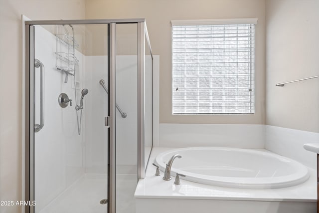 bathroom with a stall shower, a garden tub, and a wealth of natural light