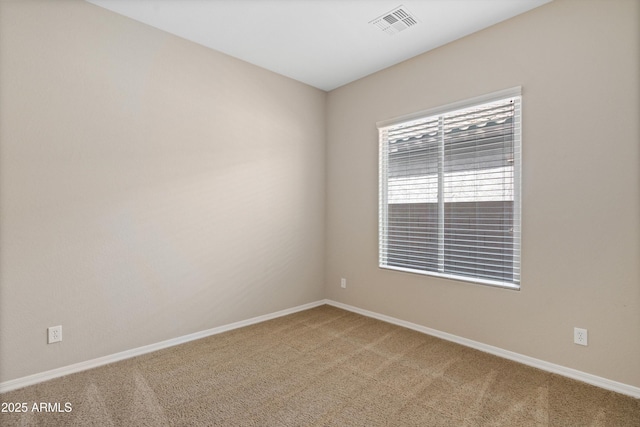 spare room with baseboards, visible vents, and light colored carpet