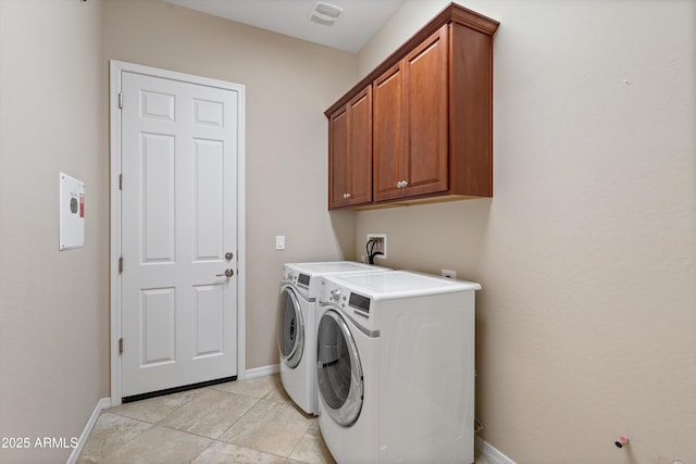 washroom featuring light tile patterned floors, independent washer and dryer, cabinet space, and baseboards