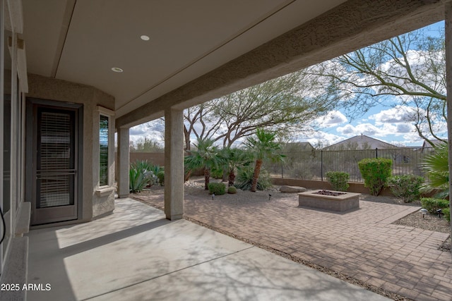 view of patio featuring a fire pit and fence